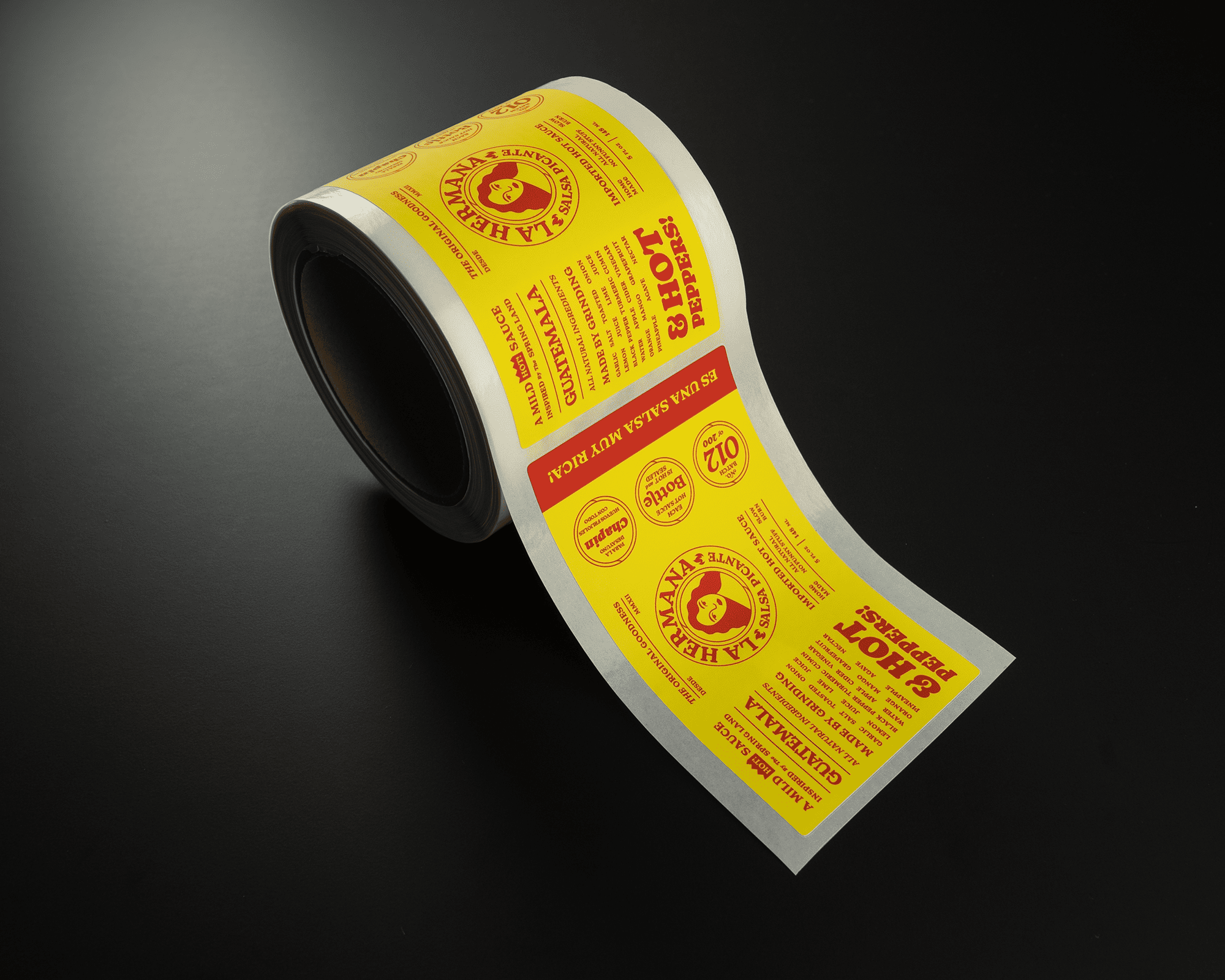 A roll of yellow and red printed labels with text and graphics, partially unrolled on a black surface.
